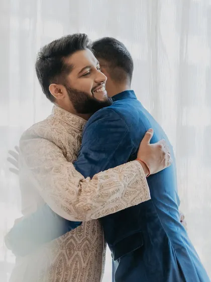 A heartwarming, candid moment of the groom sharing a hug with his friend before the wedding.
