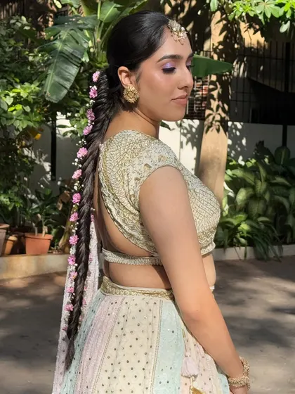 A side profile showing how the lilac eyeshadow and the floral braid come together for a cohesive and dreamy Haldi look.