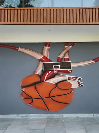 A creative and interactive mural where a basketball hoop is integrated into an anatomical heart made of a basketball. This unique piece at a home in Palam Vihar is a true conversation starter.