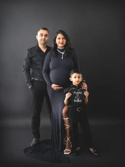 We love adding a touch of drama to our family maternity sessions. This portrait uses a classic black backdrop and matching outfits to create a powerful, stylish image, celebrating the son's promotion to 'big brother'.