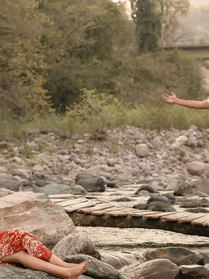 A candid and joyful moment from a pre-wedding shoot by the river in Rishikesh.