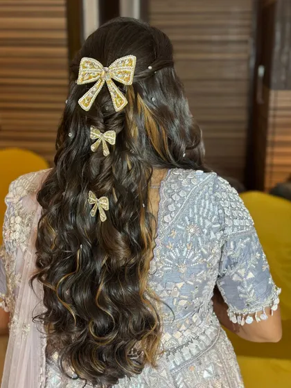 The full view of the cascading curls and bow accessories, a perfect hairstyle for a fun-filled sangeet night.