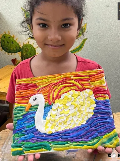 This beautiful swan, with its textured feathers and a vibrant sunset, was crafted from playdough. This activity helps children understand how to build layers and blend colors to create a scene.
