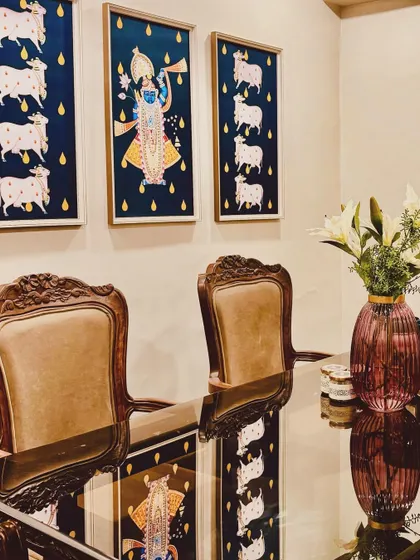 Sourcing the right art is like finding a hidden treasure. These traditional Pichwai paintings bring a story of devotion and culture to this dining space, perfectly complementing the classical carved chairs and creating a truly elegant atmosphere.