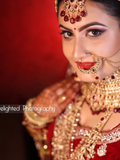 A vibrant, close-up bridal portrait. Her direct gaze and bright red lipstick give this photo a confident and bold feel.