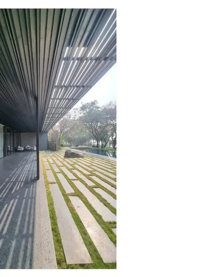 The play of light and shadow under a pergola at the Lakeshore house. The metal grid mimics the age old trees at the water's edge, while the stone pavers interspersed with grass ground the structure in its place.