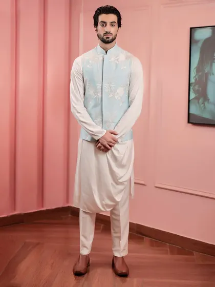 A full view of the powder blue Nehru jacket and draped kurta set. The modern silhouette of the kurta is perfectly complemented by the traditional elegance of the embroidered jacket.