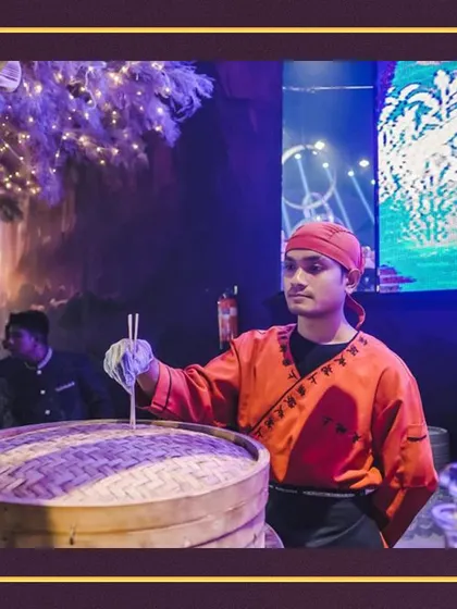 An expert chef preparing dim sum at a live Asian station. The large bamboo steamers are a classic sight, promising delicious, steaming hot dumplings for your guests.