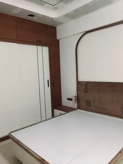 Another angle from the same project, showing the raw structure of the bed with its arched headboard design before the final finishes are applied.