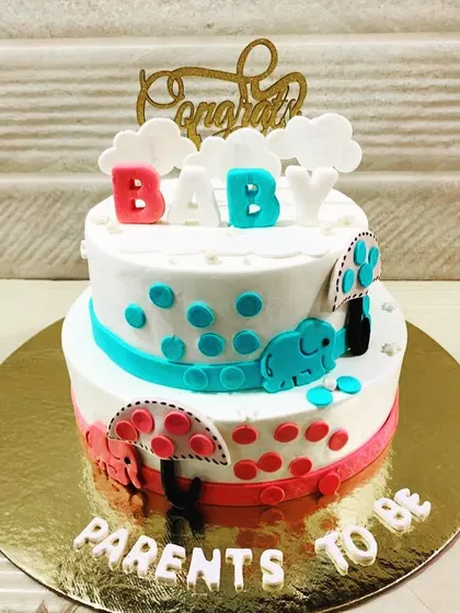 A sweet two-tiered cake to congratulate the "Parents to be," featuring cute elephants and a simple, modern design.