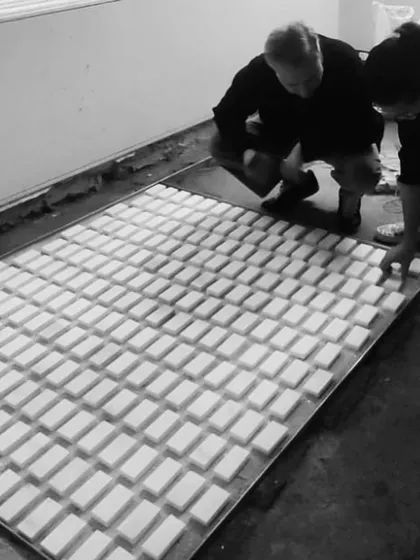Our team reviewing a full-scale mockup of a custom "biscuit" terrazzo floor pattern. This step is essential to our process, allowing us to approve the design in its real-world context.