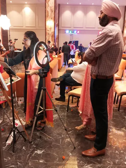 Guests often gather to watch the painting progress. Here, at a 50th-anniversary party in Faridabad, guests look on as I add details to the couple's portrait.