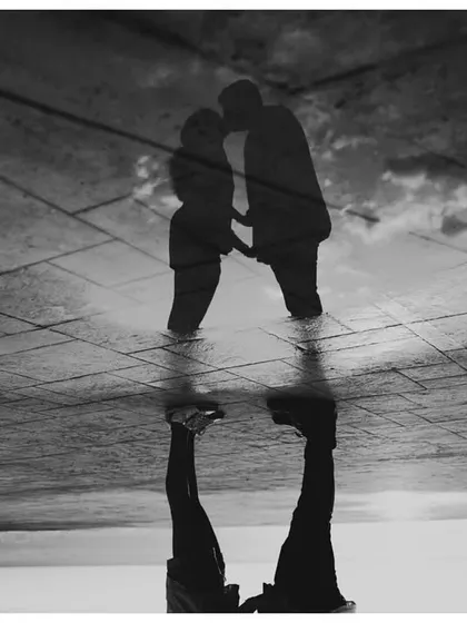 An artistic double exposure in black and white, blending the couple's silhouette with a reflection, creating a surreal and memorable image from their Malta shoot.