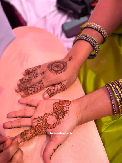 Two different guest designs being applied side-by-side, one a simple mandala and the other a traditional paisley motif.