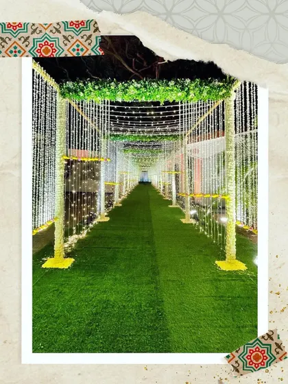 A beautiful walkway for an outdoor event. I used pillars wrapped in florals and draped with hanging light strings to create a dreamy, elegant aisle that guides guests into the main event space.