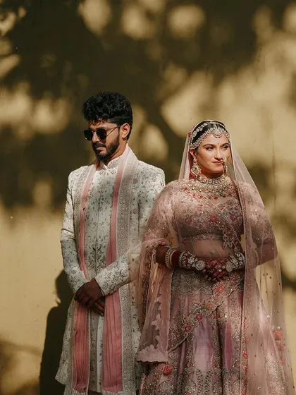 A stylish, editorial-style portrait of the couple. The play of light and shadow adds a dramatic and artistic feel to this wedding day shot.