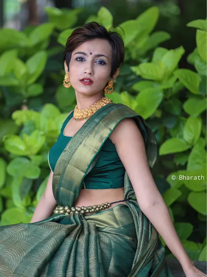 A modern take on traditional wear, this outdoor portrait pairs a beautiful green saree with a pixie haircut for a unique and stylish look.