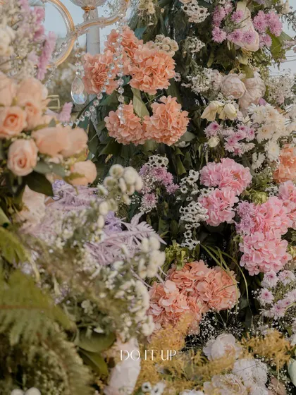 Another detail of a lush pastel floral installation. The combination of different flower sizes, shapes, and shades of pink and lavender creates a visually stunning, garden-like feel.
