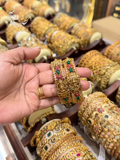 A pair of beautiful temple kadas with Lakshmi motifs and colored stonework. These are perfect for pairing with traditional sarees for festive occasions.