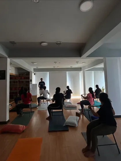 Our instructor guides students through seated poses during a therapeutic workshop, focusing on accessibility and safety.