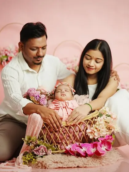 A candid moment during a family session, where the parents look down adoringly at their baby in the basket. These unposed interactions often make for the most cherished photos.