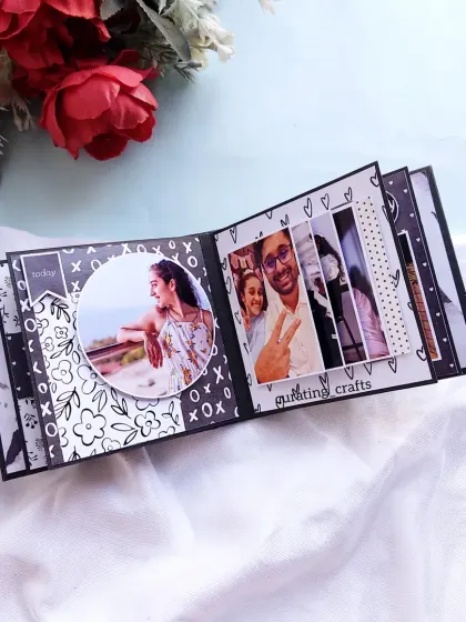 An inside page of the monochrome scrapbook, featuring a circular photo frame and a waterfall card.