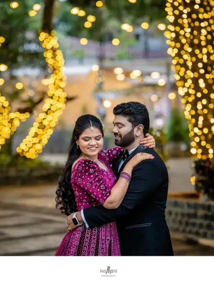 A romantic embrace under the warm glow of decorative lights, a perfect candid moment from their reception.