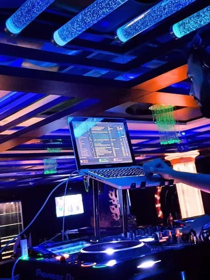 A wider view of my workspace during a set. You can see my full professional setup, integrated seamlessly into the club's environment. I bring my own reliable gear to ensure top-quality sound every time.