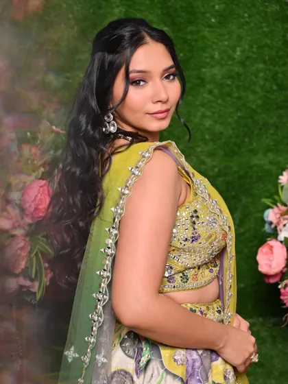 A fresh and bright Mehendi look with a green and yellow lehenga, featuring purple-toned eyeshadow for a pop of color.