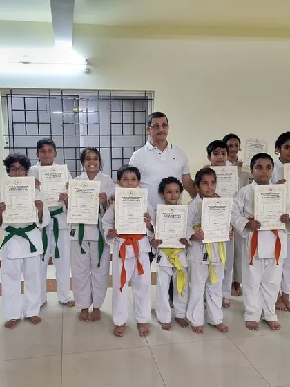A group of proud students from our PFC, Purva Belmont, and Mahavir Palms dojos pose with their Sensei after receiving their new belts and certificates.