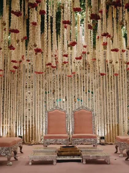 This breathtaking mandap, draped in thousands of cascading floral strings, was designed for a fairytale love story. The opulent structure and soft pink lighting created a royal ambiance fit for a palace wedding.