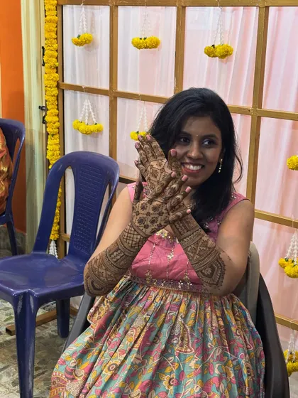 Another shot of the happy bride, showing off her beautiful henna. The design is a mix of traditional patterns and personalized elements.