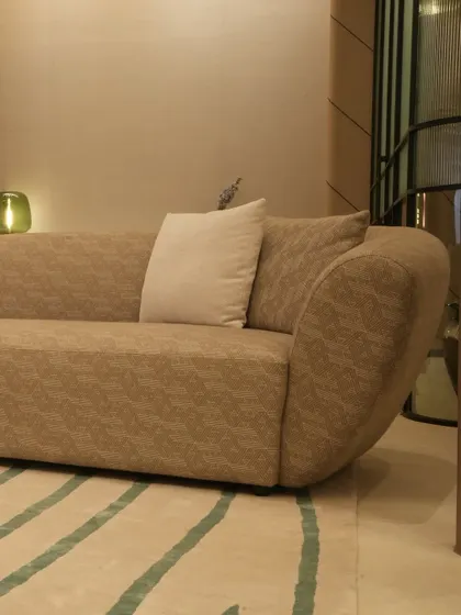 This custom sofa features a gently curved frame upholstered in a textured taupe fabric, creating a warm and inviting centerpiece. Paired with a simple off-white cushion, it showcases our ability to create comfortable, modern seating that is rich in texture.