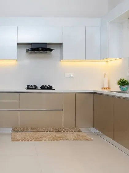 The full view of this kitchen showcases the integrated refrigerator and the balance between the upper white cabinets and the lower beige ones. It’s a harmonious and functional space.
