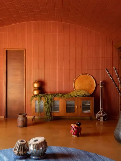This view highlights the rich, monolithic color of the terracotta vault and walls, creating a cozy and enveloping atmosphere in the living area.