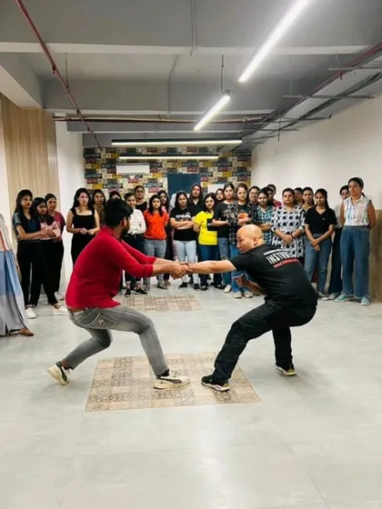 A demonstration of breaking a double wrist grab during a corporate women's safety session. This move is fundamental for escaping a control situation.