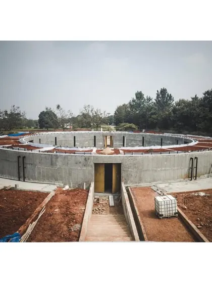 An eye-level view of the gallery structure during construction. This perspective shows the human scale of the project and the labor involved in creating the precise concrete forms.