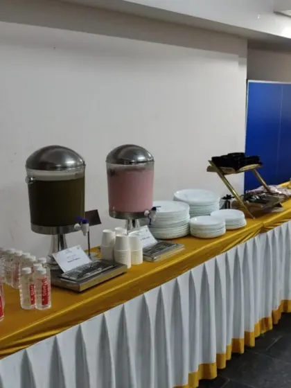 Our beverage and appetizer station, complete with juice dispensers, bottled water, and neatly stacked plates, ready for guests to arrive.