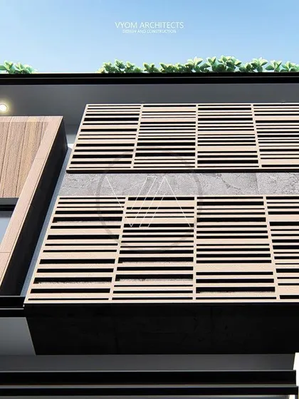 A close-up of the Manjulamma residence, showing the intricate pattern of the wooden louvered screen. This element provides sun shading while adding a rich, textural detail to the facade.