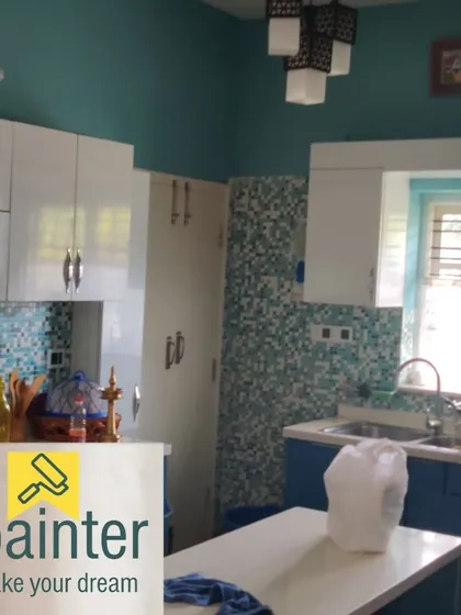 A kitchen with teal walls and a blue and white mosaic tile backsplash. The wall color was chosen to perfectly match the vibrant tiles.