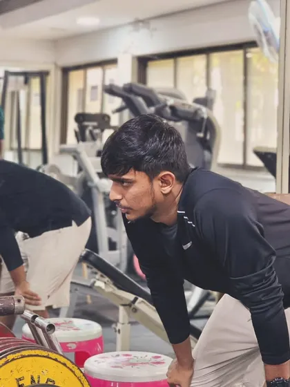 Players focus on their form during a weightlifting session in the gym, building the foundational strength required for high-level badminton.