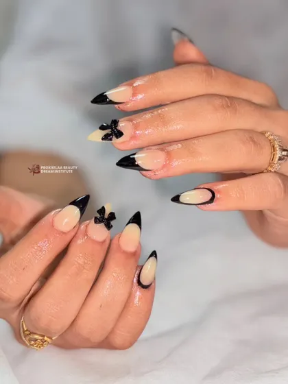 A detailed shot of the chic black French tips with 3D bows. The stiletto shape enhances the elegance of the design, making it both modern and timeless.