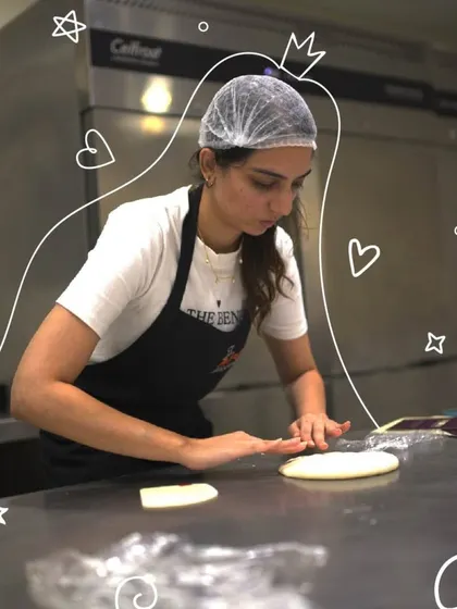 A participant carefully rolls out dough on a professional steel countertop. In our workshops, you learn the proper techniques for handling and shaping different types of bread.