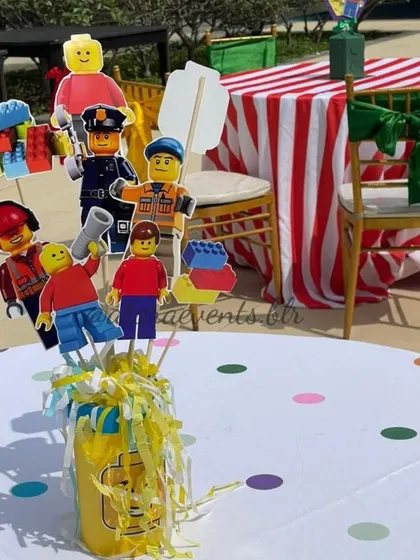 Themed table centerpieces featuring various LEGO minifigure cutouts add a fun and personalized touch to the kids' dining area.