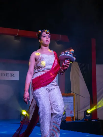 A model showcases a creative outfit inspired by planets, complete with a themed handbag.