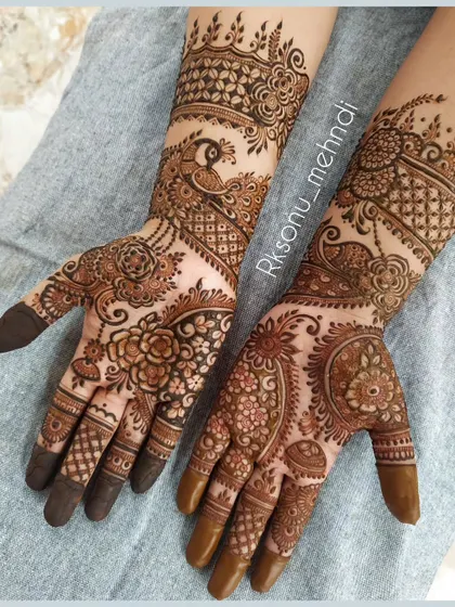 This half-hand designer mehndi is perfect for any occasion. It combines classic floral and peacock motifs with modern paisley and net patterns for a unique and elegant look.