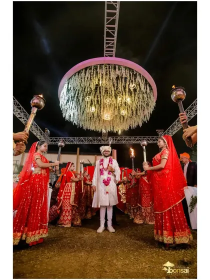 The groom's grand entrance, surrounded by performers with torches.