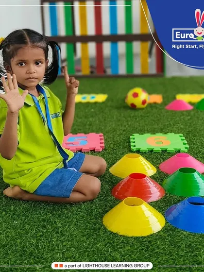 This young learner is counting with her fingers while surrounded by colorful cones and number puzzles. This hands-on math activity helps children develop a strong number sense through play.