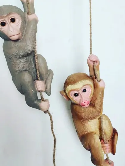 Our garden decor range includes these hanging monkey figures, shown gripping ropes in grey and brown finishes against a white background.