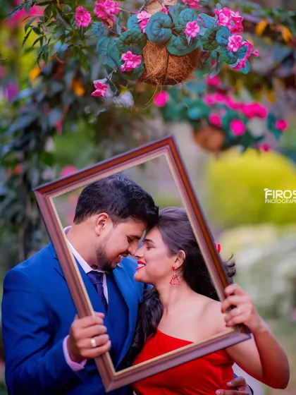 Another angle of the couple framed by a picture frame, capturing their loving gaze. This prop adds a playful and artistic element to the shoot.